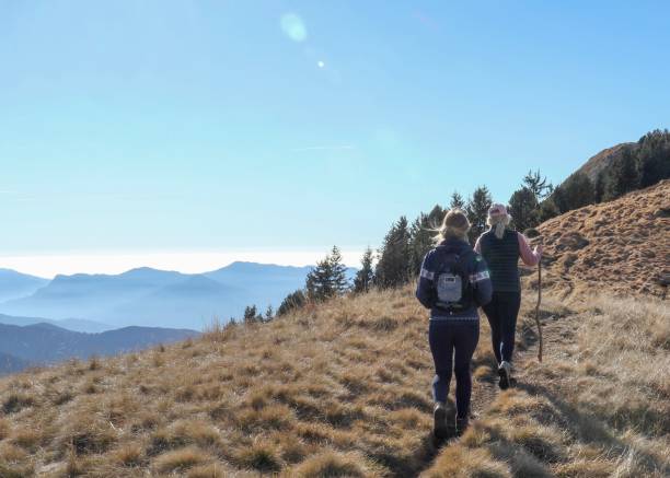 istock Hikers walk along sunny mountain ridge 1301833086
