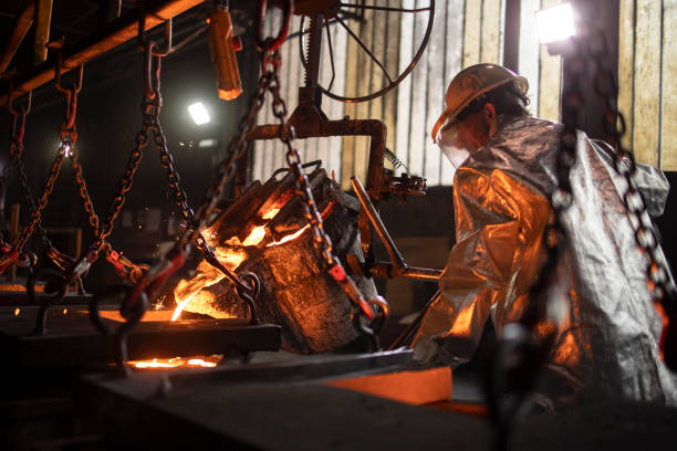 istock Steel casting process. Worker in foundry filling molds with molten iron. 1301834517