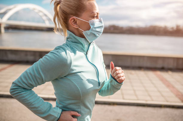 istock Young woman running with face mask on. 1301835407