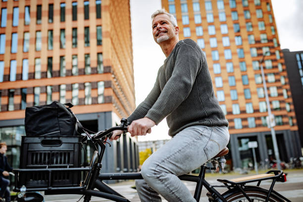 istock Mature grey hair man riding bicycle and contributes to eco-friendly environment 1301839496