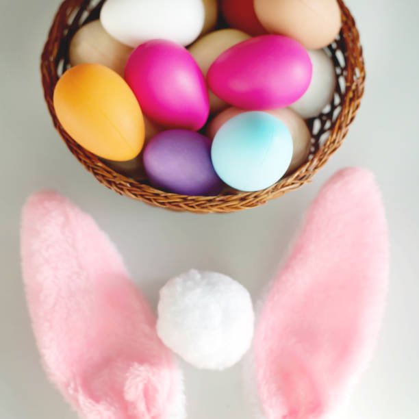 istock Bright Easter eggs made of plastic, rabbit ears on a white table. Happy Easter! Decorating the kitchen for Easter on a Sunny day. 1301839506
