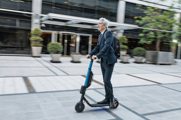 istock Mature Latino businessman on electric scooter going to work, blurred motion image 1301840429