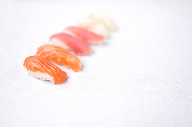 Nigiri sashimi with salmon, tuna, Seabass. Nigiri sushi set on a white background. Delicious traditional Japanese food, tasty seafood, restaurant concept, food background.