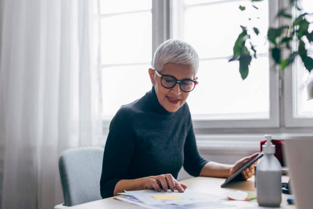 istock Experienced Female Designer Working on a Project at the Desk of her Office Using a Tablet Computer 1301843332