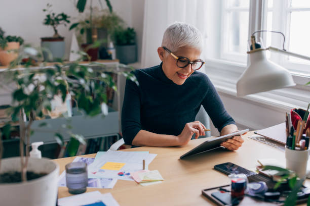 istock Experienced Female Designer Working on a Project at the Desk of her Office Using a Tablet Computer 1301843348