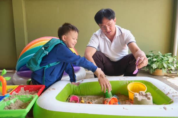 istock Happy Asian father and son are playing with sand at home 1301845575