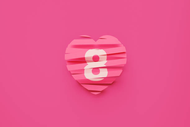 Number 8 written over pink heart which is made of pink ribbons over pink background. Horizontal composition with copy space. Copy space available. Women's Day Concept.