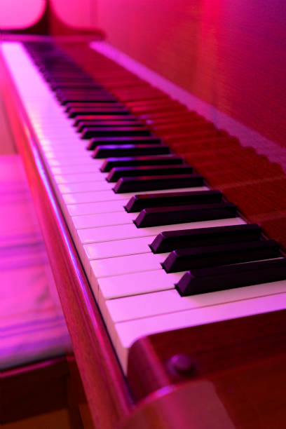 istock Golden Wood Piano Bathed in Purple Light 1301848992