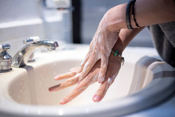 istock Woman washing her hands at home 1301849203