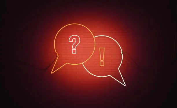White and red neon speech bubble pair with question mark and exclamation point symbols sitting over black wall. Horizontal composition with copy space. Q and A and warning concept.