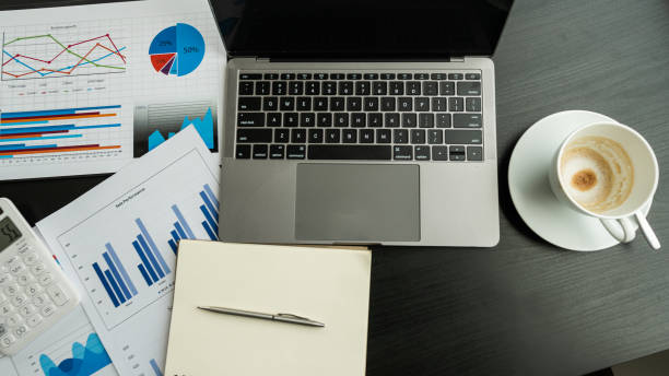 istock Laptop computer and graph with coffee cup on the black table in the office 1301857959