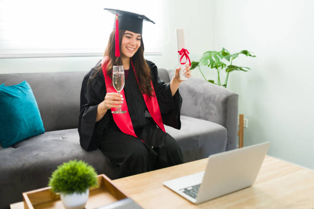 istock Beautiful woman drinking wine while graduating at home 1301861484