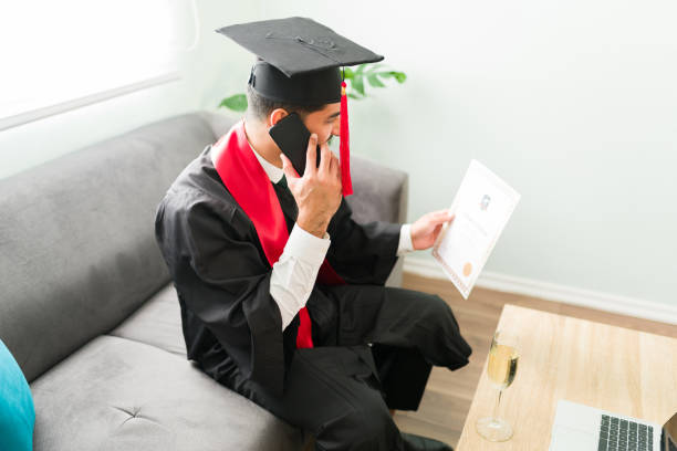 istock Male graduate speaking on his smartphone while sitting on the sofa 1301862518