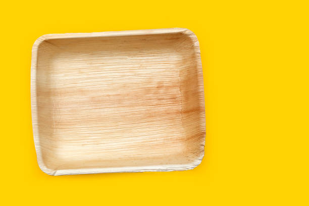 istock Betel palm leaf plates on yellow background. 1301865651