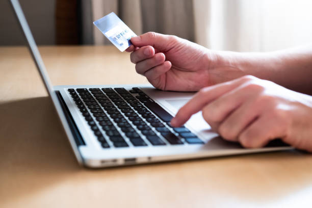 istock Men hand holding credit card and type payment information on keyboard for order online shopping. Internet technology and Digital market place E-Commerce lifestyle concept, Purchase transaction. 1301868713