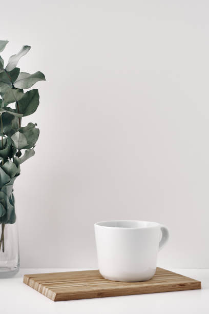 istock A mug, wooden board and a transparent vase with eucalyptus branches. Eco-friendly materials in interior decor, minimalism. Copy space, mock up. 1301870973