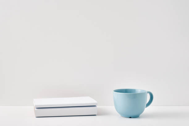 istock The mug stands on a stack of books on a white background. Natural and eco-friendly materials. Copy space, mock up 1301870980