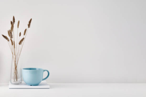 istock A transparent vase with dry branches, a book and a mug on a white background. Minimalism, eco-materials in the interior decor. Copy space, mock up. 1301870988