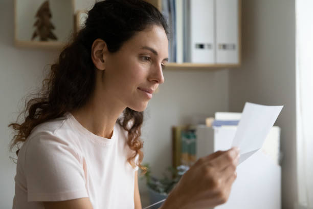 istock Attentive young lady engaged in reading important financial legal document 1301871005