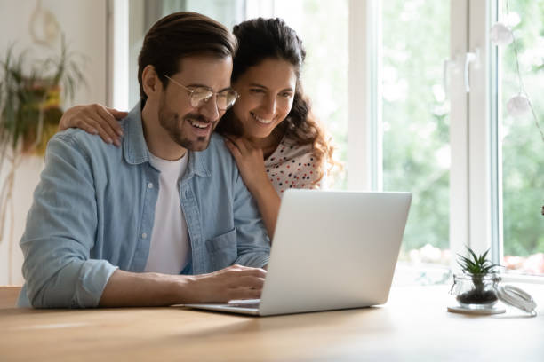 istock Young spouses looking at computer screen choosing tour on vacation 1301871022