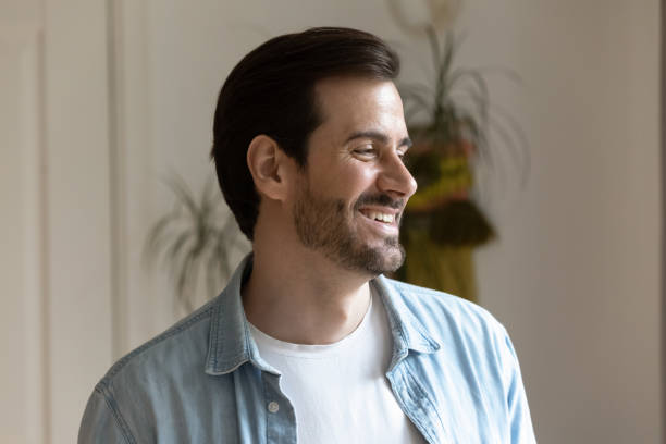 istock Handsome smiling bearded millennial man distracted from camera looking aside 1301871046