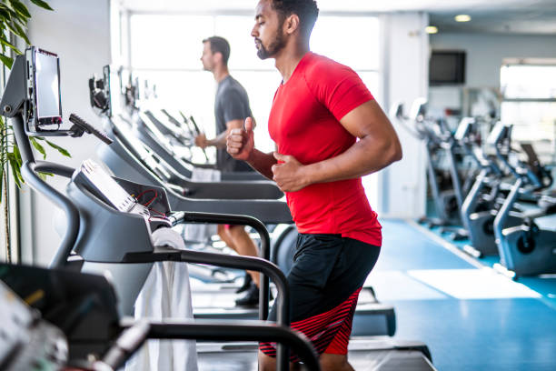 istock Fit and Focused Mid Adult Men Using Treadmills at Gym 1301879234