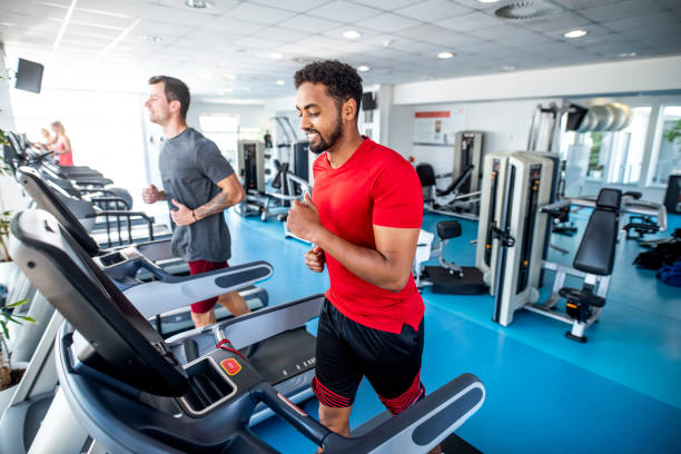 istock Fit and Focused Mid Adult Men Using Treadmills at Gym 1301879236