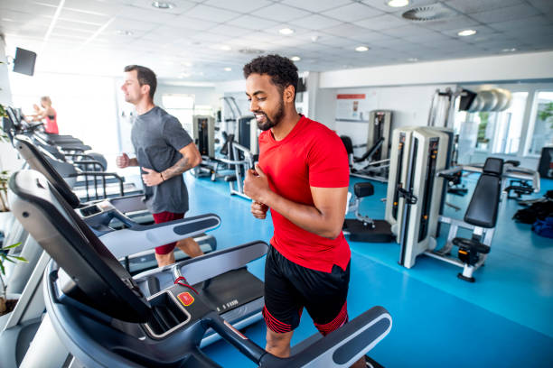 istock Fit and Focused Mid Adult Men Using Treadmills at Gym 1301879239