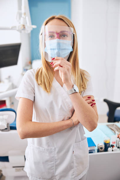 istock Attentive blonde woman looking through plastic mask 1301880071
