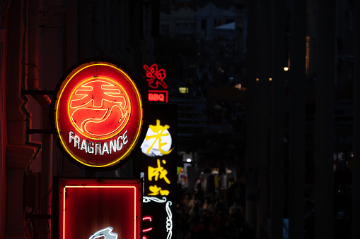 A neon chinese fragrance sign seen at night in the district of Chinatown in Singapore, Asia.