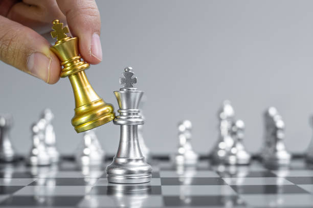 istock businessman hand moving gold Chess King figure and Checkmate opponent during chessboard competition. Strategy, Success, management, business planning, disruption and leadership concept 1301881932