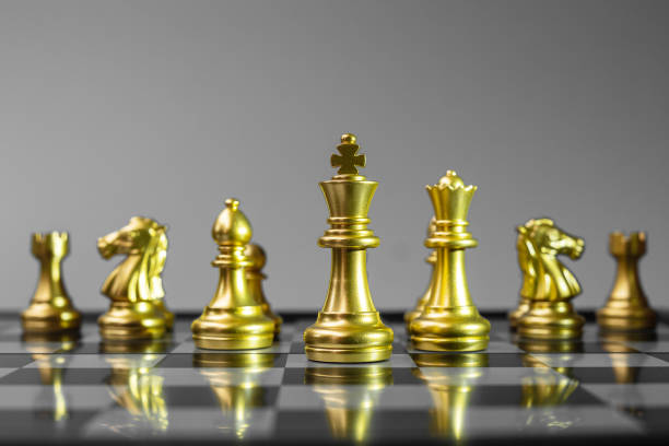 istock Gold Chess figure team (King, Queen, Bishop, Knight, Rook and Pawn) on Chessboard against opponent during battle. Strategy, Success, management, business planning, think, education and leader concept 1301882476