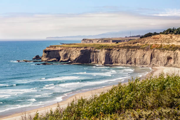Tunitas Creek Beach - Half Moon Bay California Steep cliffs jut into the Pacific Ocean north of Tunitas Creek Beach near Half Moon Bay with Pillar Point and Mavericks Beach on the horizon in San Mateo County, California. mavericks california stock pictures, royalty-free photos & images
