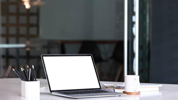 istock Computer laptop with blank screen, coffee cup and office supplies on office desk. 1301886682