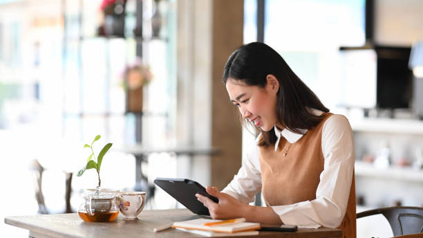 istock Cheerful young female designer working on her project with digital tablet while sitting in modern office. 1301886683