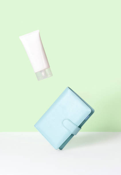 istock Creative layout with levitating beauty product and notepad on green background 1301888163