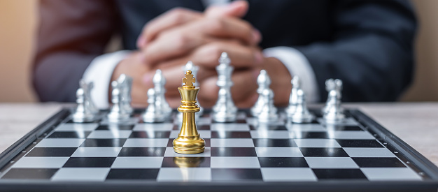 chess King figure against chessboard opponent with businessman manager background. Strategy, Success, management, business planning, tactic, politic, thinking, vision and leadership concept