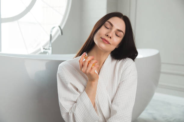 Young brunette woman portrait with perfume jar in hand stock photo
