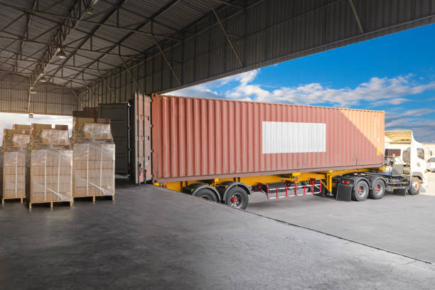 istock Cargo trailer truck parked loading at dock warehouse. Cargo shipment. Freight truck transportation. 1301889078