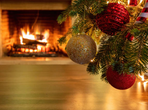 istock Xmas tree branch with colorful baubles, blur burning fireplace background, copy space. 1301895563