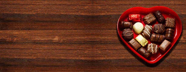 istock chocolate piece from various type in heart box for valentine's day on wood table 1301898789