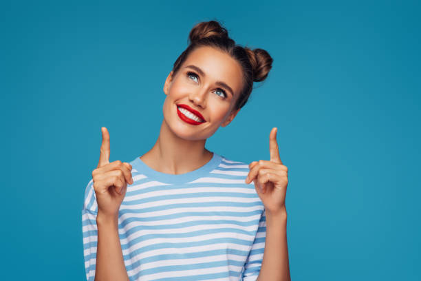 istock Beautiful girl pointing up presenting your product 1301899690