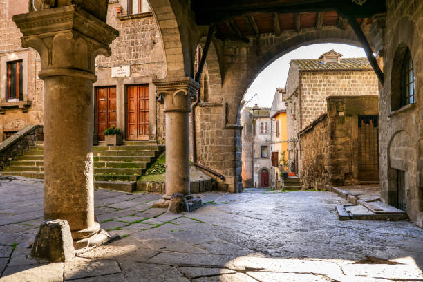 the beautiful stone portico in the square of san pellegrino in the medieval heart of viterbo in central italy - paving stone cobblestone road old imagens e fotografias de stock