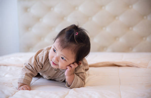 istock Cute Baby Crawling On Bed At Home 1301903688