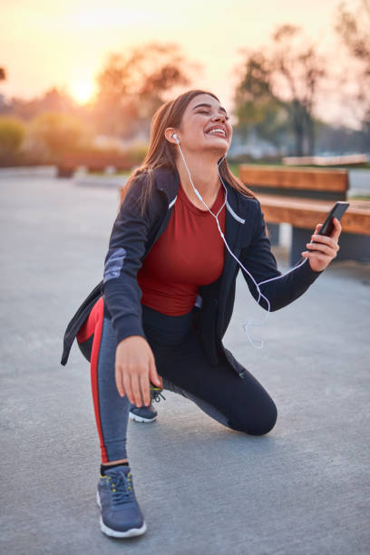 istock Modern young woman with cellphone making pause during jogging / exercise. 1301905388