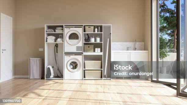 Laundry Room With Beige Wall And Parquet Floor With Washing Machine Dryer Laundry Basket And Folded Towels In The Cabinet Stock Photo - Download Image Now