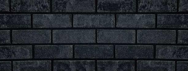 istock Black shabby brick wall close-up wide texture. Dark grey brickwork grunge widescreen background 1301910770