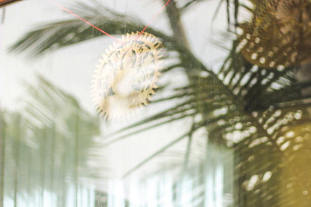 istock Wooden buddha symbol behind the window with palm trees reflection 1301910776