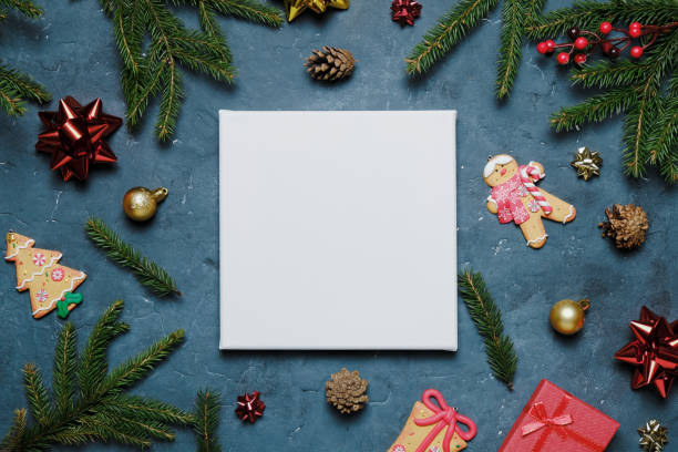 Blank canvas board with Christmas decoration on blue background. Mockup poster frame, Christmas and New Year concept. Top view. blank christmas card stock pictures, royalty-free photos & images