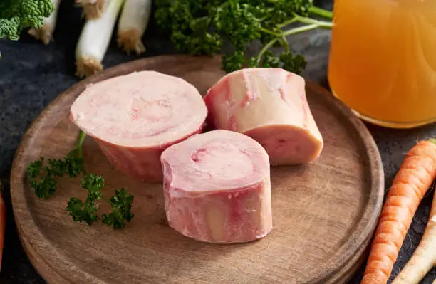 Beef marrow bones and fresh vegetables - ingredients to prepare broth or soup